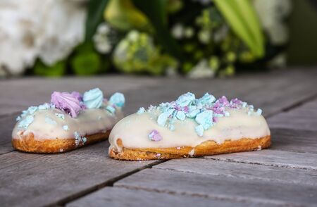 Tasty eclairs on wooden table, close up