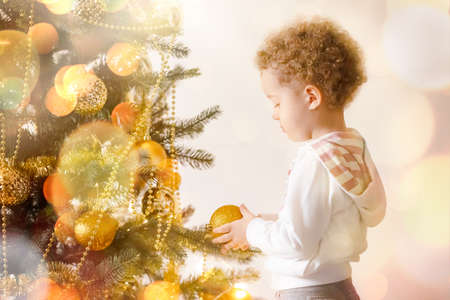 boy kid near christmas tree, magic new year with gifts and good moodの写真素材