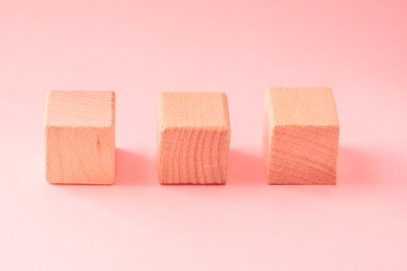 Abstract geometric real wooden cube with surreal layout on pink backgroundの写真素材