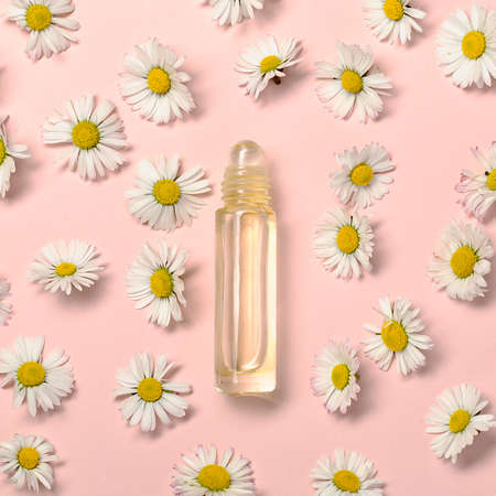 Pattern with daisy flowers and bottle on pink backround.の写真素材