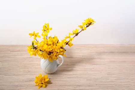 Yellow flower bouquet in vase on table with copy spaceの写真素材