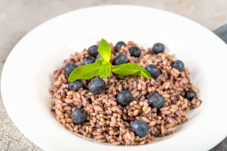 Delicious risotto with blueberries served on lihgt grey concrete tableの写真素材