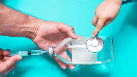 Syringe with vaccine on blue background from above