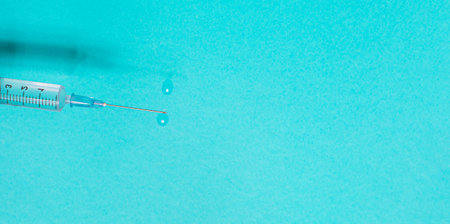 Syringe with vaccine on blue background from aboveの写真素材
