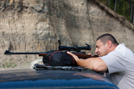 the man aiming from a rifle