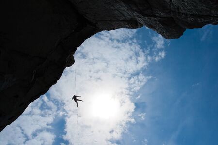 climber abseils on the sky backgroundの写真素材
