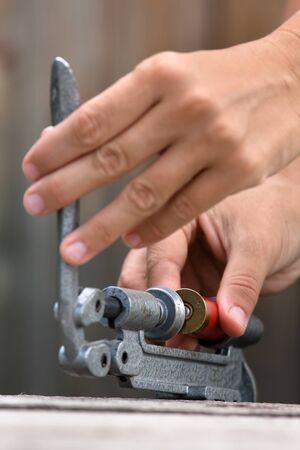 hands reloading cartridge by shotgun shell reloader, closeup