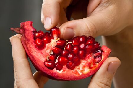 hands of woman peeling pomegranate fruit, closeupの写真素材
