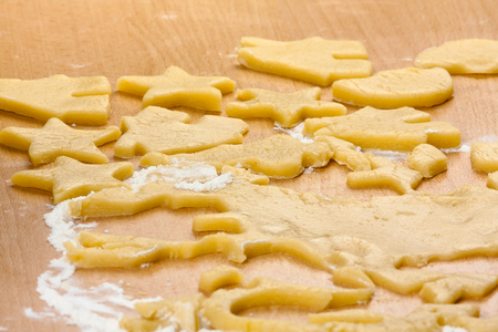 Cutting Christmas gingerbread cookies from rolled out doughの写真素材
