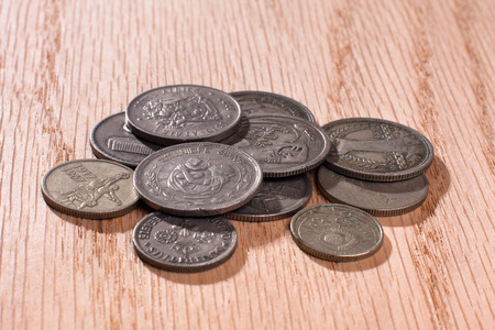 pile of coins different currencies on wooden background, closeupの写真素材