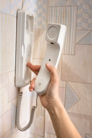 hand pressing a button on the intercom at home, closeup