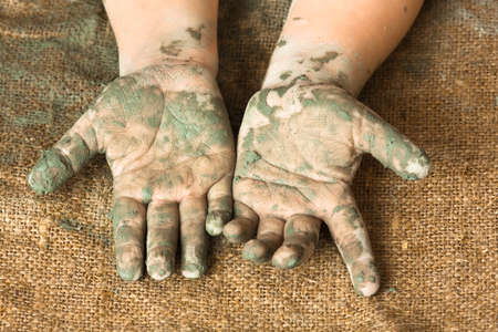hands of child after working with blue clay, closeup