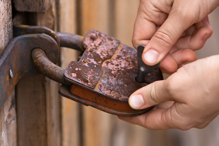 closeup of women hands opening the padlock