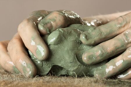 hands of ceramist kneading raw blue clayの写真素材