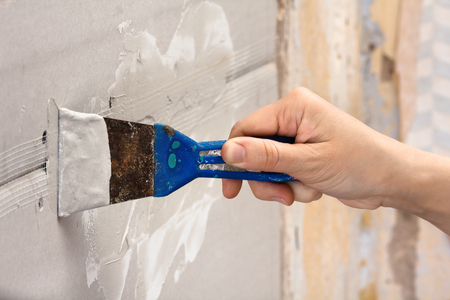 hand plastering wall with spatula during repairの写真素材