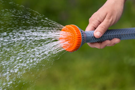 hand watering garden with sprinkler on blurred background, closeupの写真素材