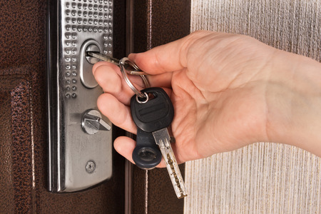 hand unlocking front door with key, closeupの写真素材