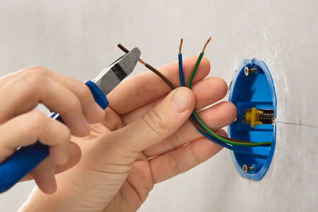 hand of electrician striping the insulation of wiresの写真素材