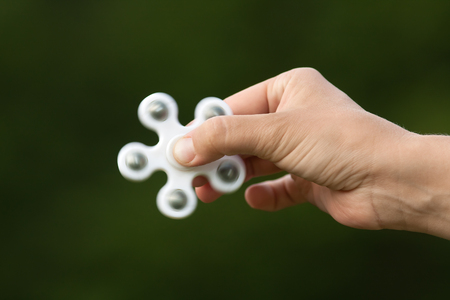 hand with popular toy white fidget spinnerの写真素材