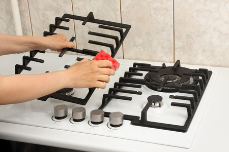 hands of woman cleaning gas cooker in the kitchenの写真素材