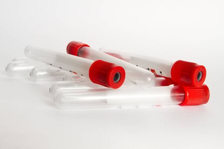 there are several clean blood test tubes with red cap on the table