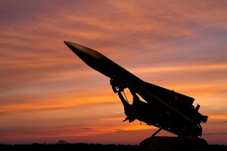 dark silhouette of a Soviet anti-aircraft missile against the background of the dawn skyの写真素材