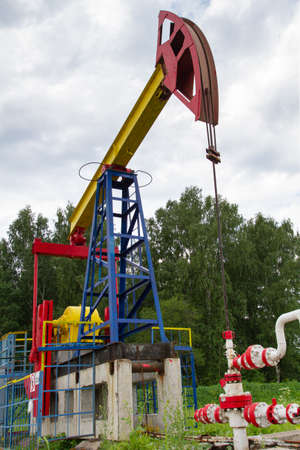oil pump stands on an oil field in a summer forestの写真素材