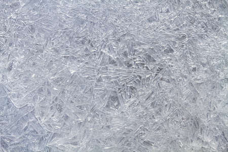 A patterned surface of ice, consisting of melted and then frozen ice needles. Abstract winter background for Christmas.の写真素材