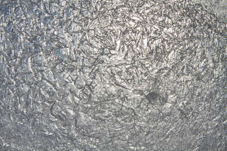 The patterned surface of transparent ice, through which the sun shines through. Abstract winter background for Christmas.の写真素材