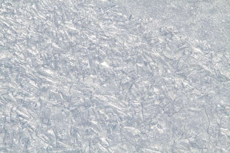The patterned surface of the ice, formed by small rounded pieces of ice and frozen water stains. Abstract winter background for Christmas and New Year.の写真素材
