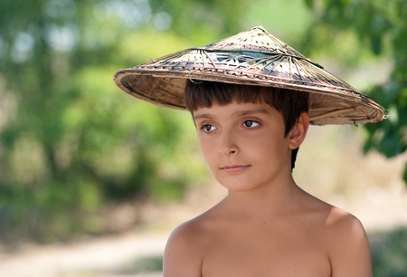 Boy in Vietnamese hat is looking sidewaysの写真素材