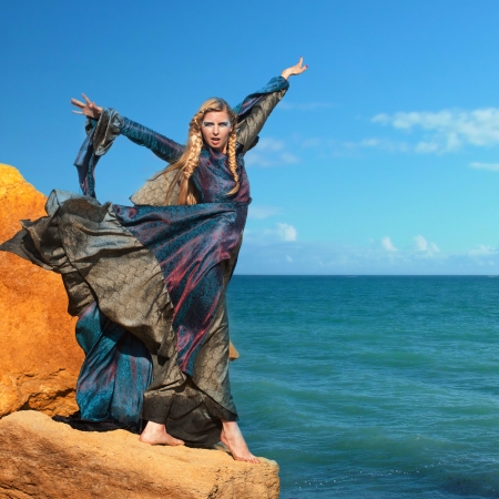 Fantasy style portrait of woman in blue dress at the seashoreの写真素材