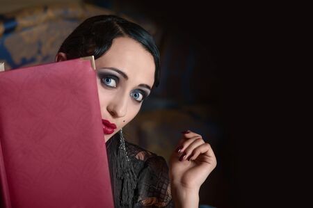 Retro style woman with menu book  looking out 