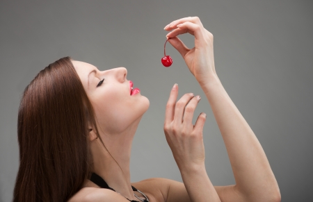 Portrait of a beautiful woman with candied cherryの写真素材