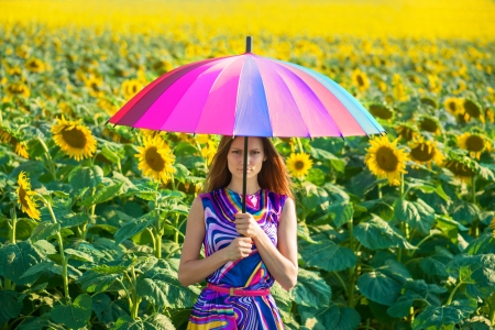 Girl with colorful umbrella in the sunflower fieldsの写真素材