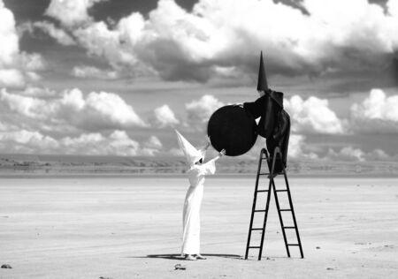 Strange figures in black cloak and white cloak fasten the black moon to firmament  Artworkの写真素材