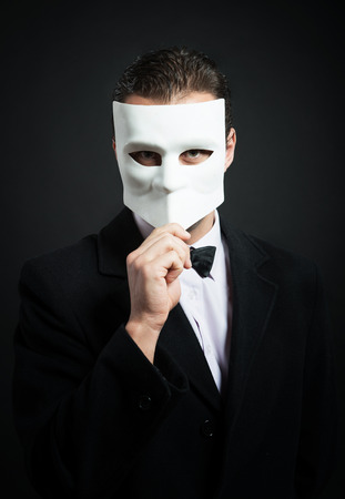 Man holding a mask in front of his faceの写真素材