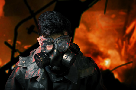 yberpunk stalker soldier in chemical protection armor and googles with flames on background