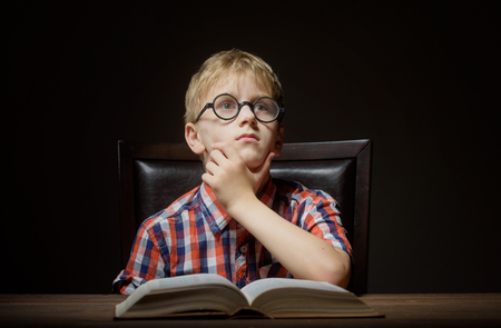 Boy dreaming with a bookの写真素材