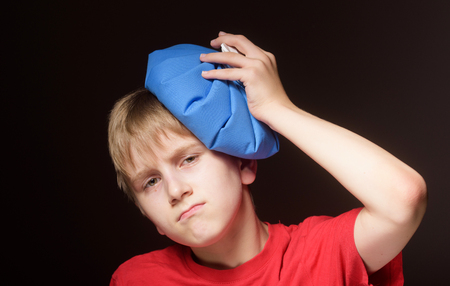 Boy with ice pack on his headの写真素材