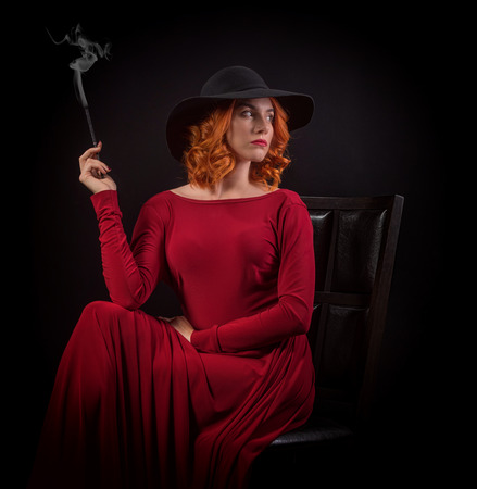 Smoking woman in red dressの写真素材