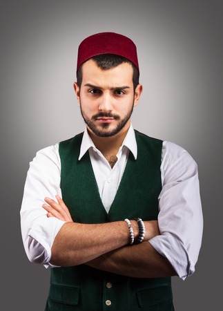 Studio portrait of a sullen Turkish man with arms acrossの写真素材