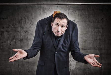 Man in suit hanging in the wardrobe. Embarrassing situation conceptの写真素材