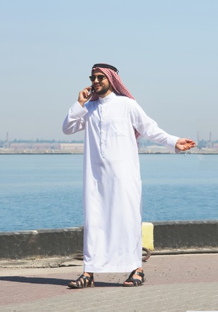 Arabian man talking on the cell phone in the portの写真素材