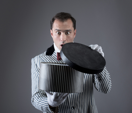 Surprised magician looking into a boxの写真素材