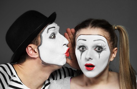Male mime sharing secret with surprised female mimeの写真素材