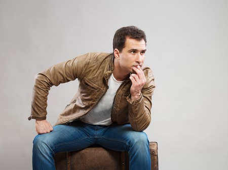 Tourist sitting on his suitcaseの写真素材