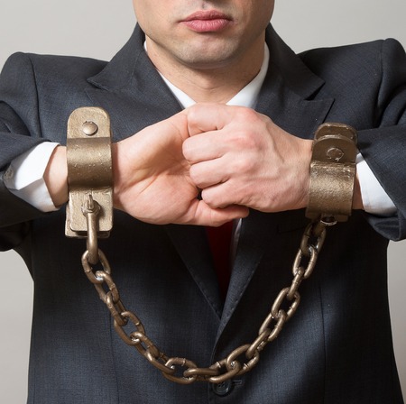 Businessman with chained hands