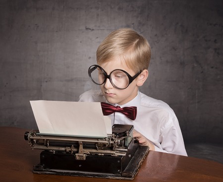 Dreaming boy with the typewriter. Retro style portraitの写真素材
