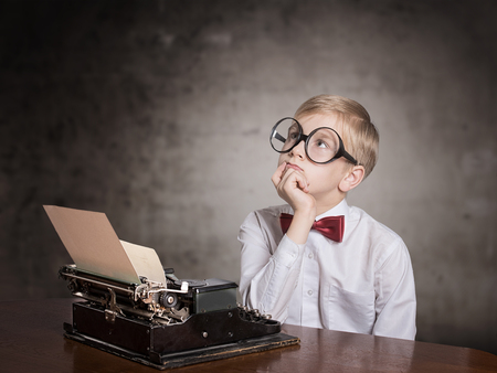 Dreaming boy with old typewriter. Retro style portraitの写真素材